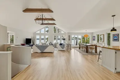 Open-concept living and dining area under cathedral ceiling — Chalet Beach House — Lac-Simon, Outaouais