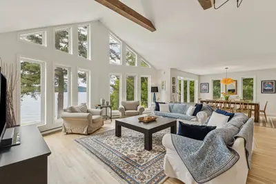 Living room with wood fireplace and lake-facing window — Chalet Beach House — Lac-Simon, Chelsea region