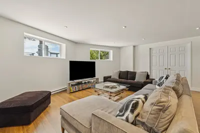 Family room with sofa and TV for movie nights — Chalet Beach House — Lac-Simon, Quebec