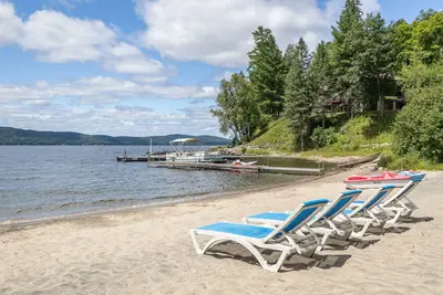 Adirondack chairs on the private sandy beach — Chalet Beach House — Lac-Simon, Quebec