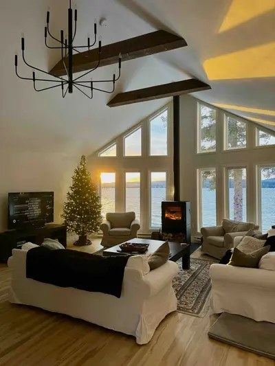 Living room with wood fireplace lit in winter — Chalet Beach House — Lac-Simon, Outaouais