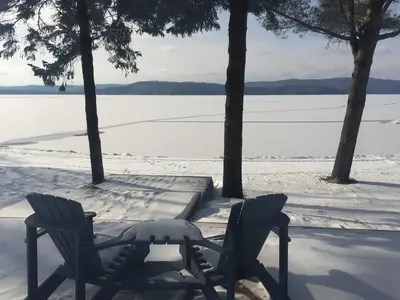 Snow-covered chairs above the frozen Lac-Simon in January — Chalet Beach House — Lac-Simon, Outaouais